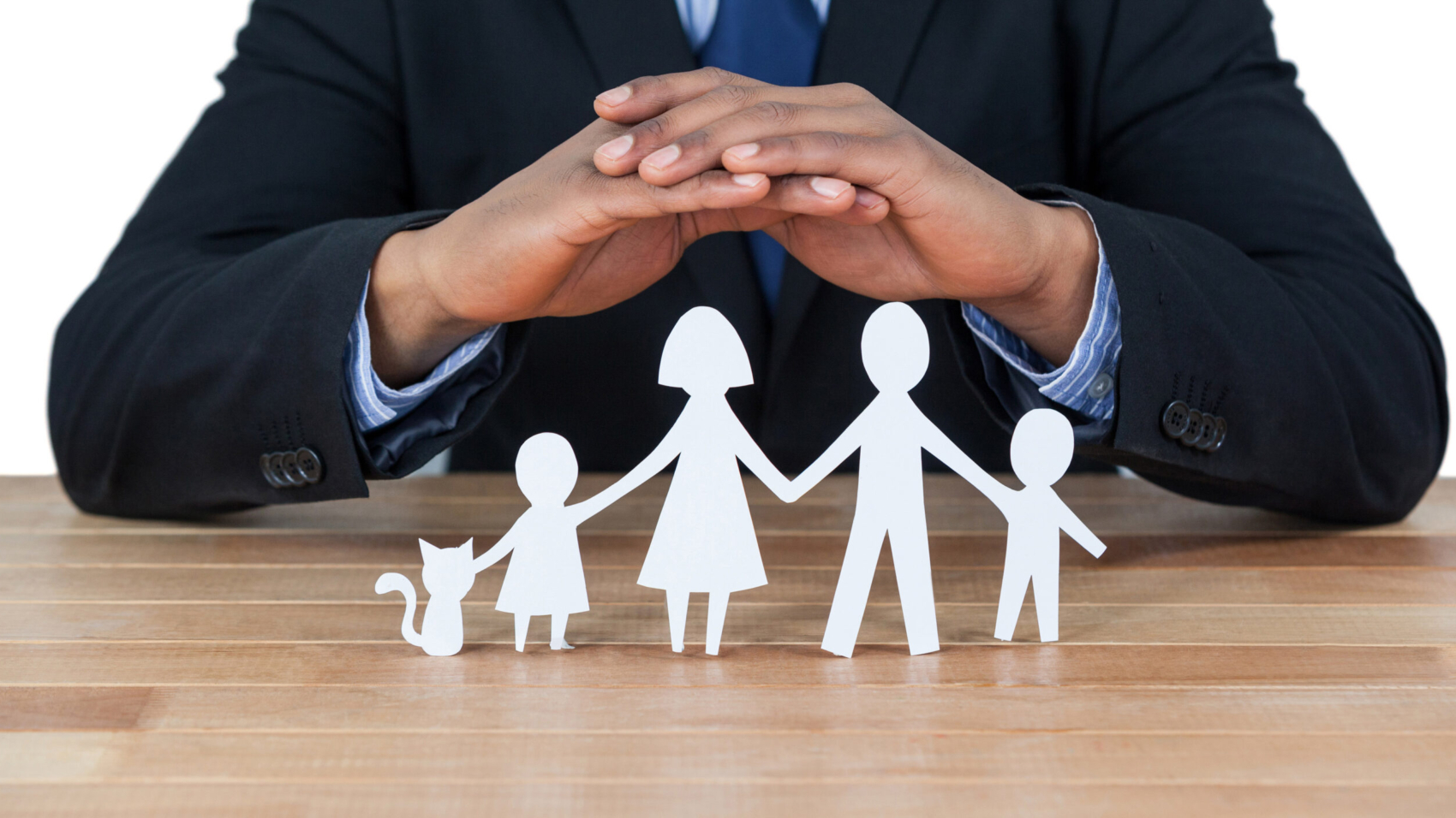 Mid section of businessman protecting paper cut out family, house and car with hands