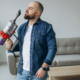 Man doing house work with accumulator vacuum cleaner