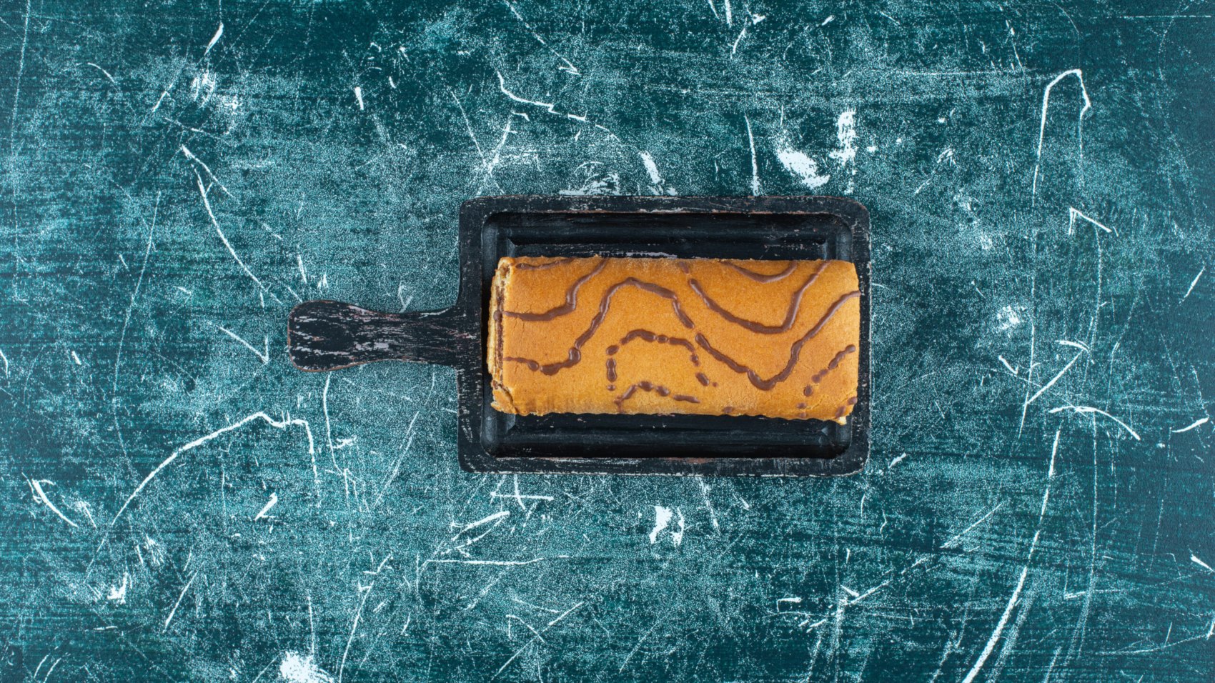 Roll cake on a board , on the blue background. High quality photo