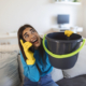 Shocked Woman Calling Plumber While Collecting Water Leaking From Ceiling Using Utensil