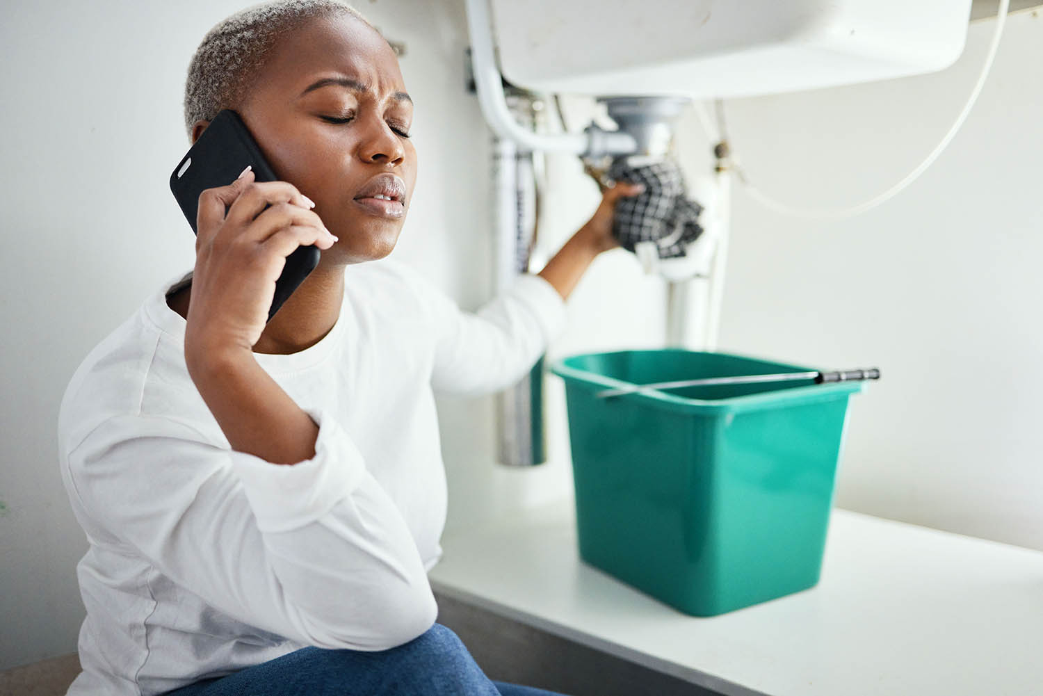 Phone call, anxiety and plumbing with black woman and sink for maintenance, construction and leak. .
