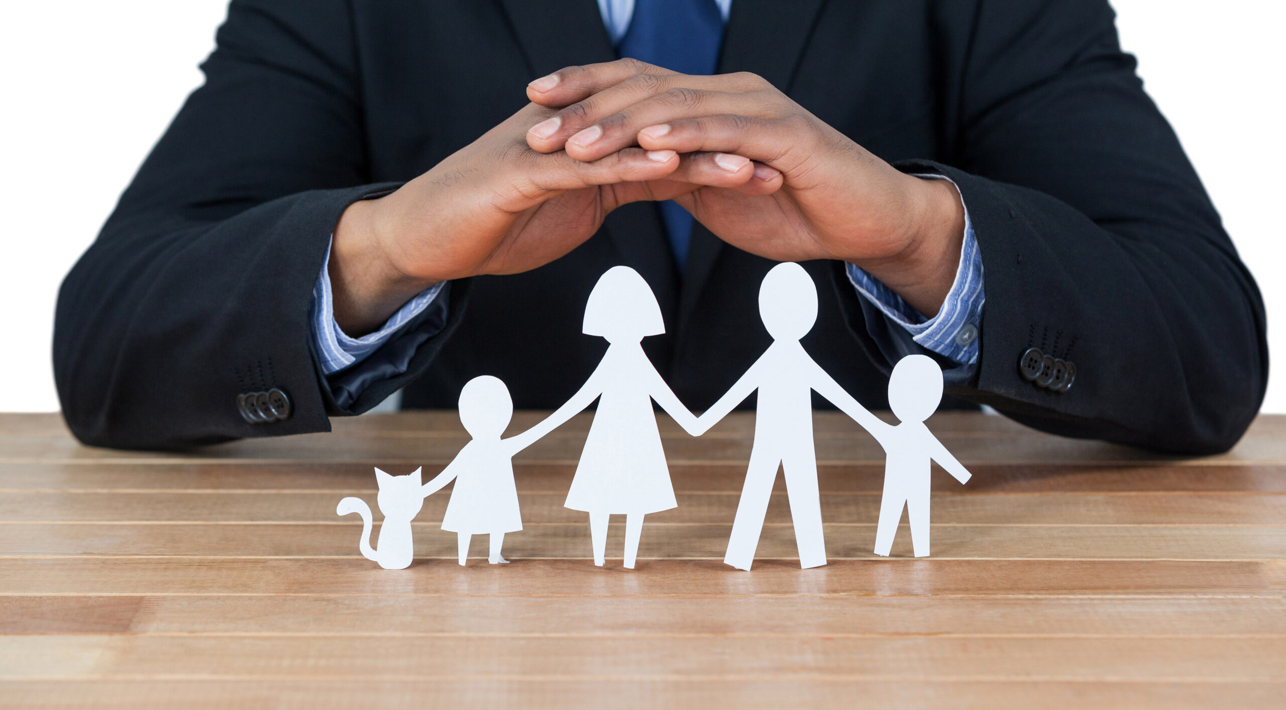 Mid section of businessman protecting paper cut out family, house and car with hands