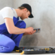 Construction worker electrician assembles an electrical outlet in an apartment.