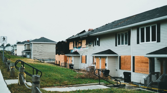 Fire-damaged apartment building with boarded windows