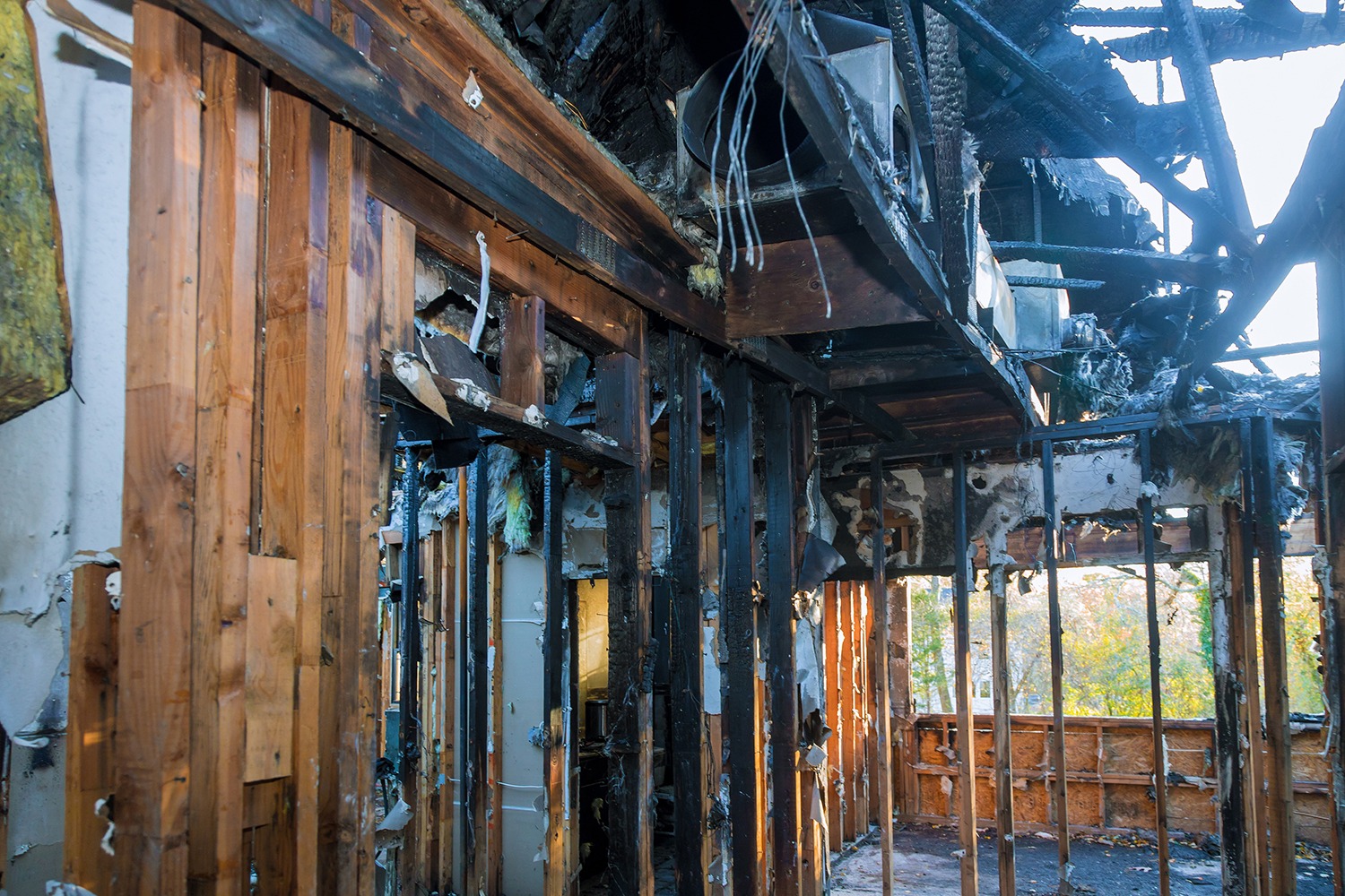 Interior of a home with charred walls and roof damage