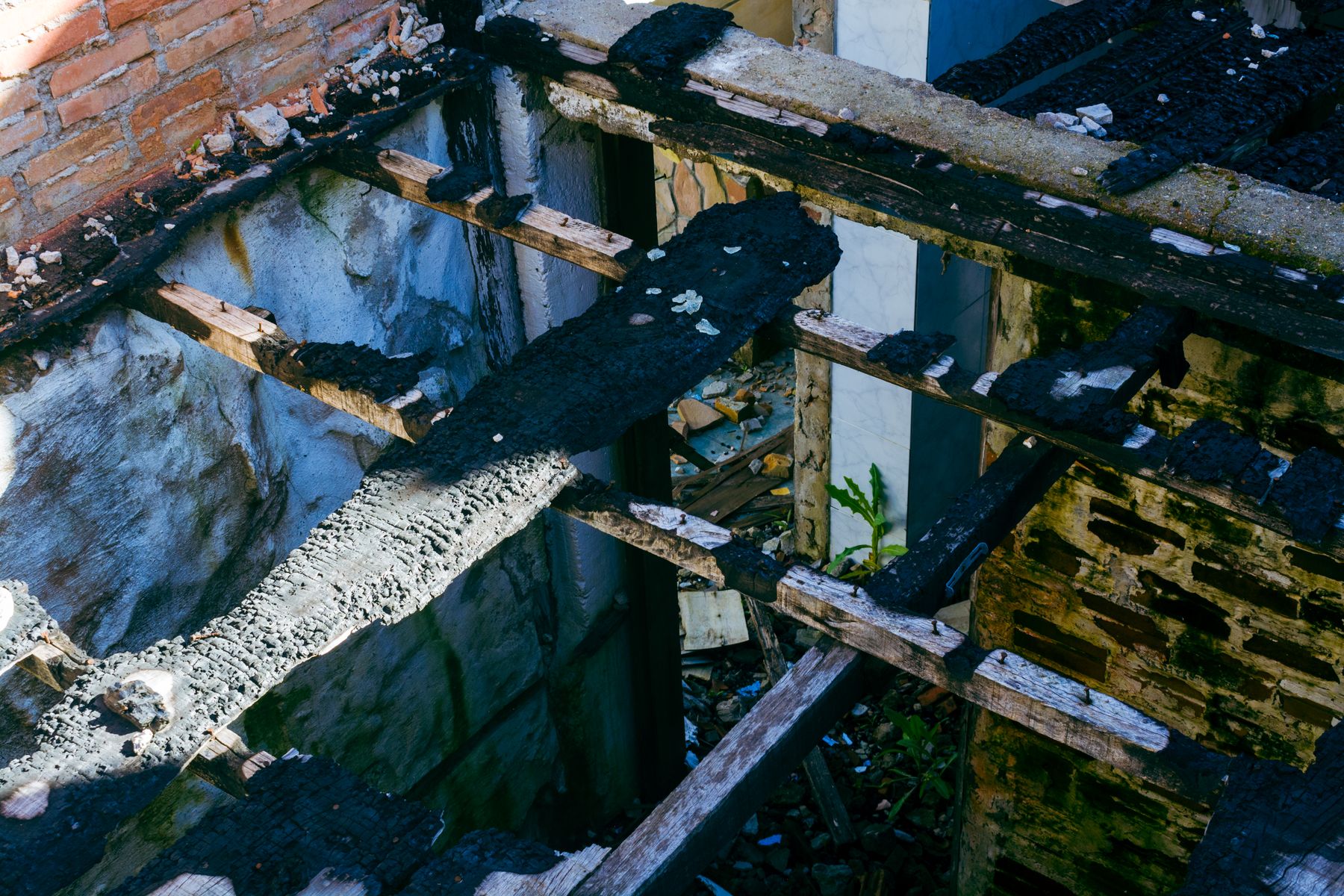 Burned wooden beams inside a fire-damaged structure